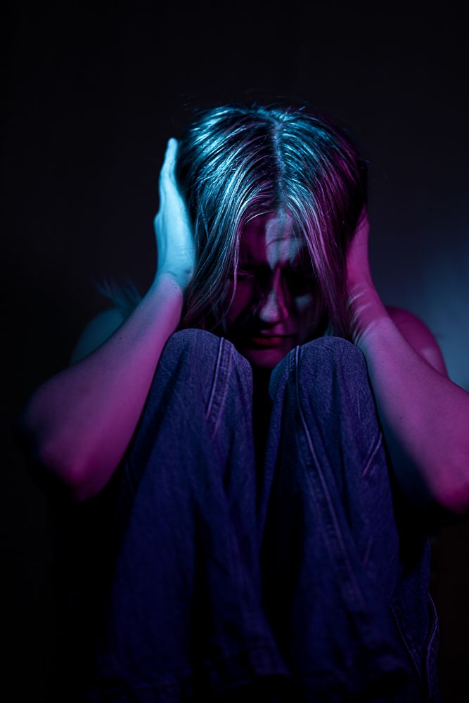 Expressive portrait series with person covering face under dramatic blue and pink lighting.
