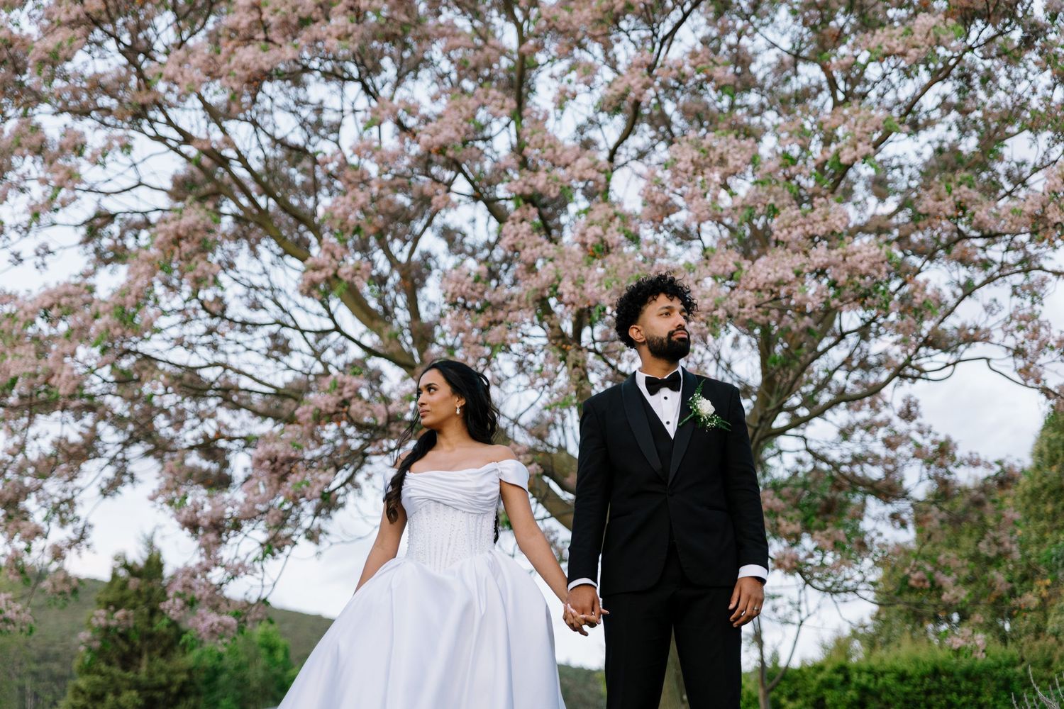 Minimalist white architectural wedding venue framing couple in formal attire.
