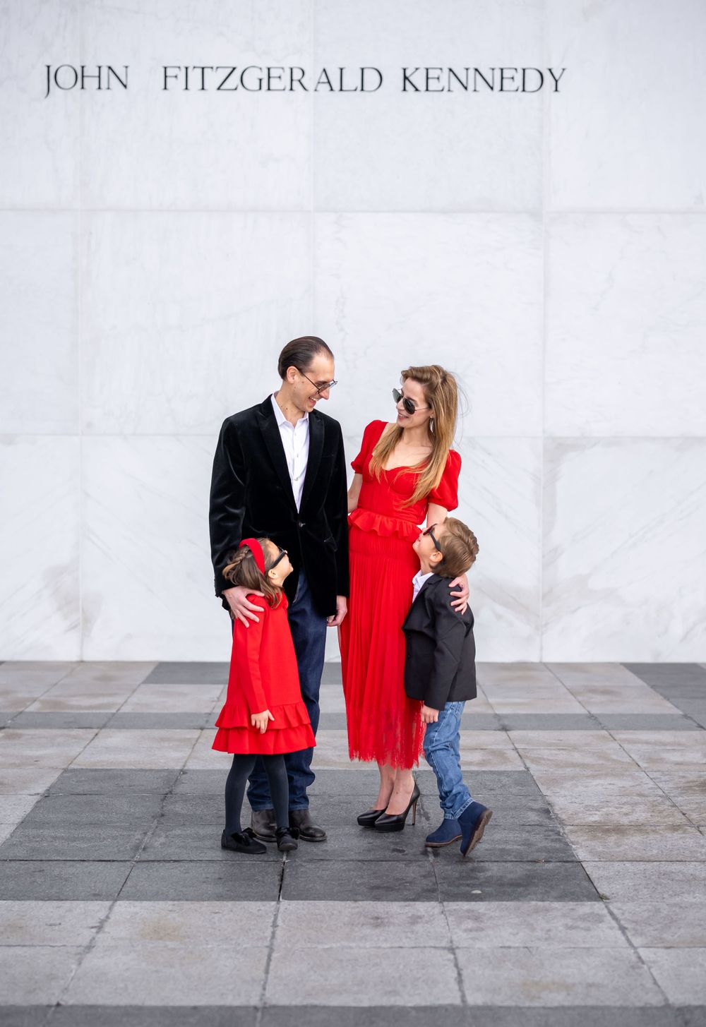 Elegantly dressed family posing in front of the iconic columns of the Kennedy Center in Washington, D.C