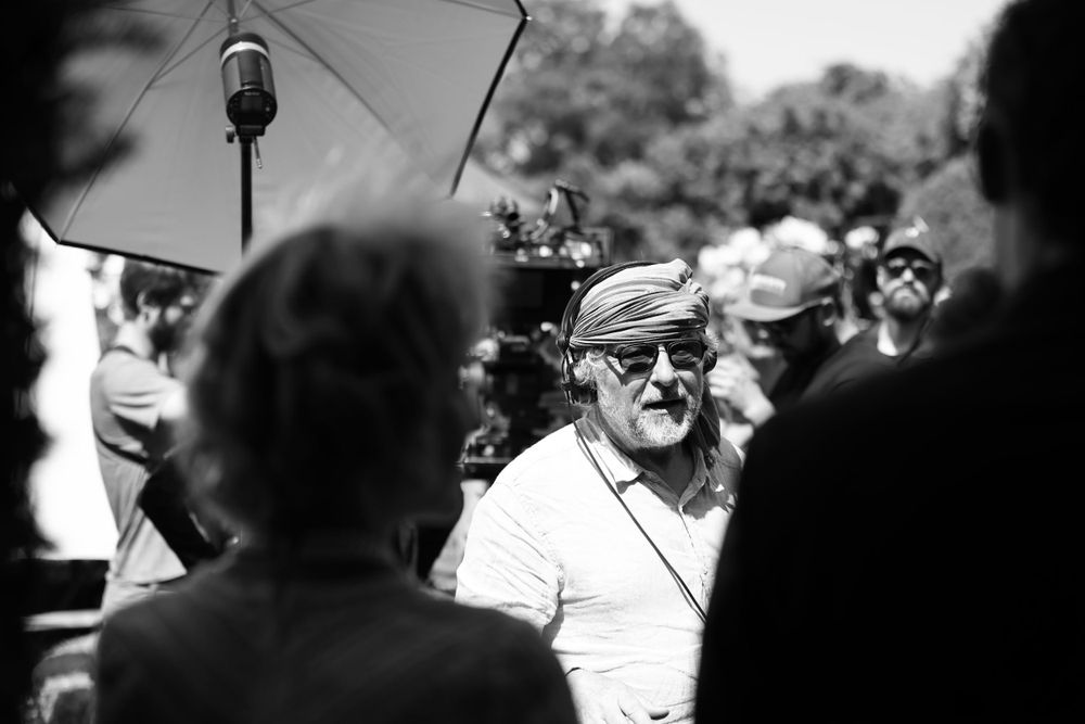 Behind-the-scenes black and white photo of film production crew with lighting equipment.