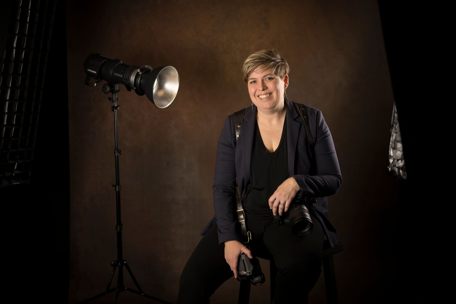 Dark studio photography setup with professional lighting equipment and black backdrop.