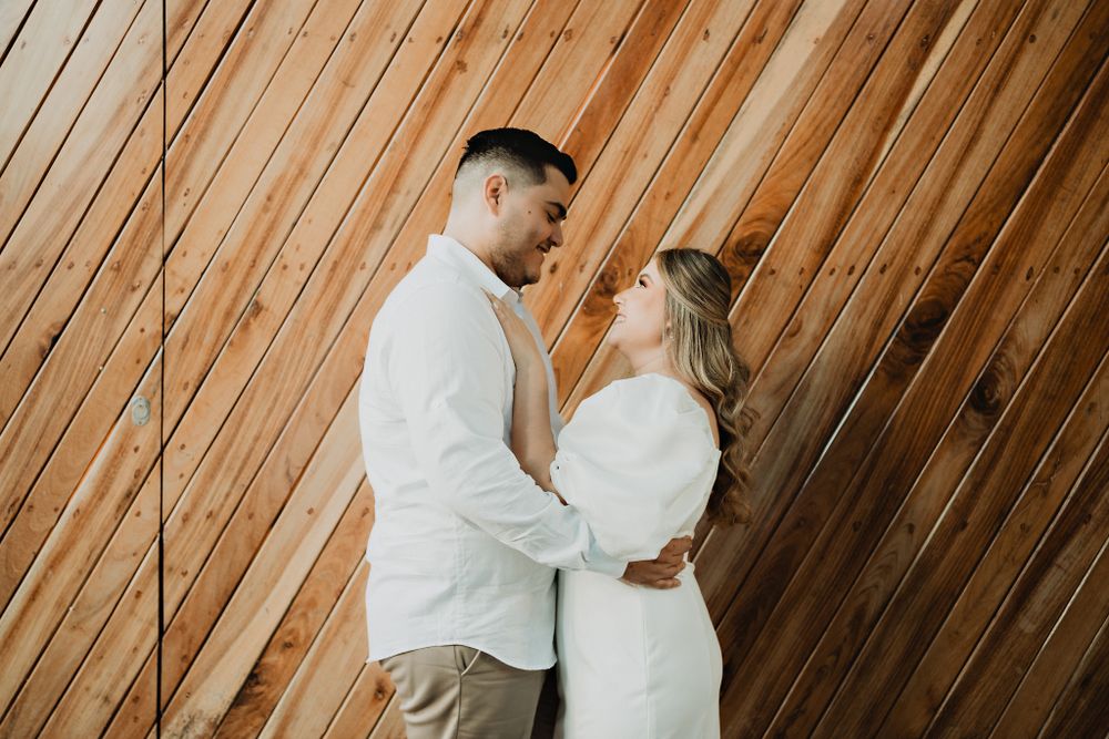 The couple embraced against a striped background, highlighting their connection in Mazatlán