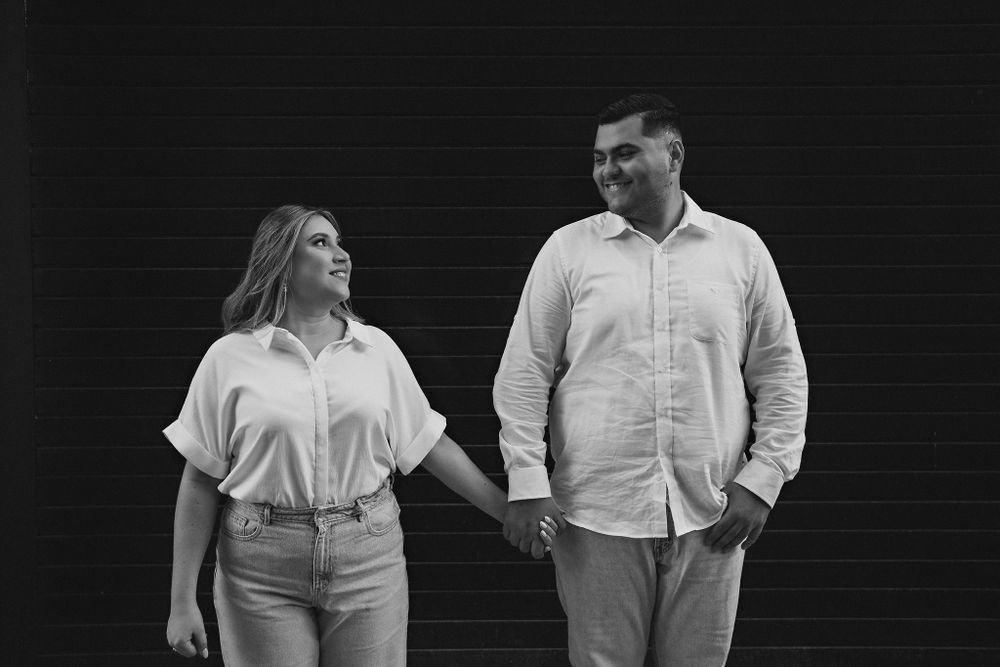 Holding hands, gazing at each other, with a dark background that highlights their bond in Mazatlán