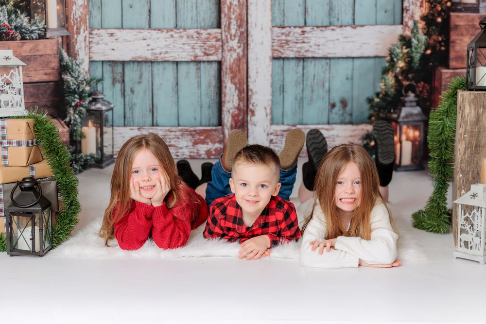 A family sits in a snowy outdoor setting wearing matching red and white holiday outfits for a winter portrait. studio session clayton nj