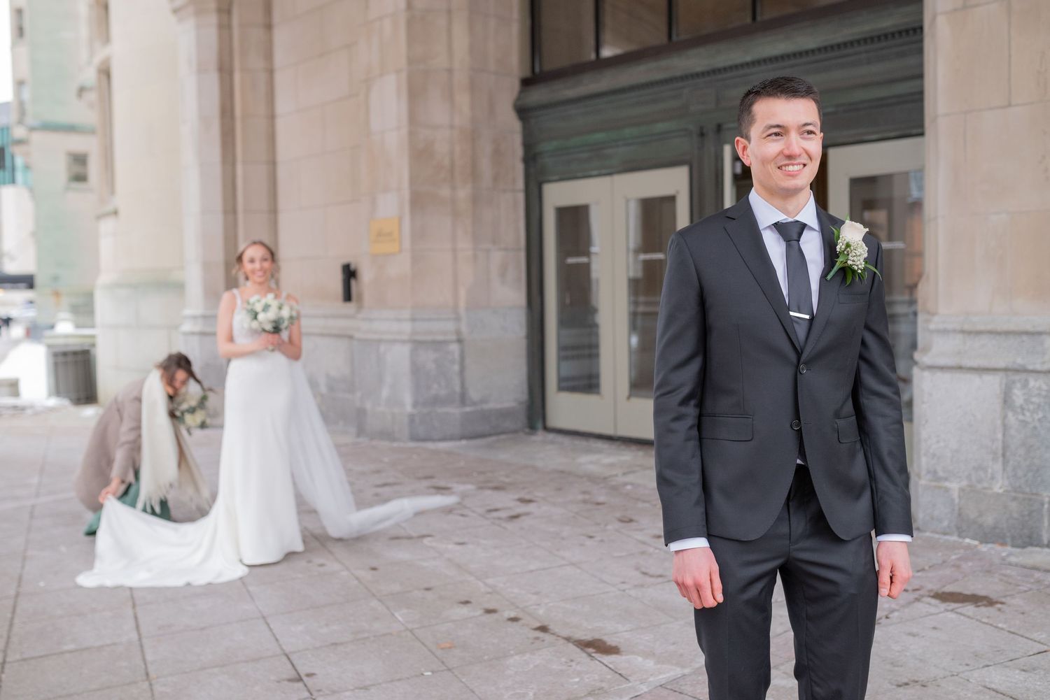 Bride and groom share joyful first look in front of Château Laurier in winter
