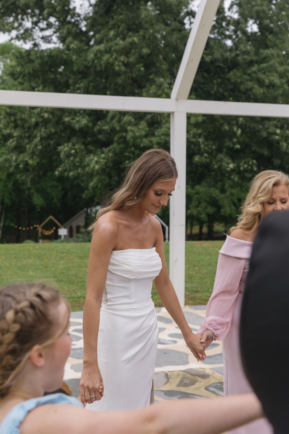 Bride and her family sharing a prayer on her wedding day at the venue at twin oaks