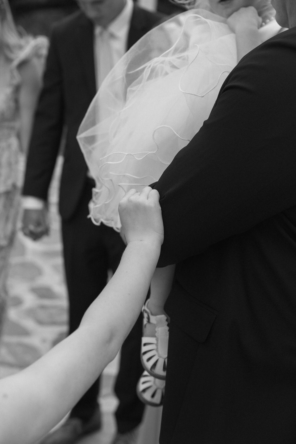 An up close detail photo of a flower girl's hand during a wedding day prayer