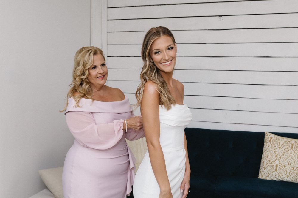 Bride's mom zipping up her dress on her wedding morning in north georgia
