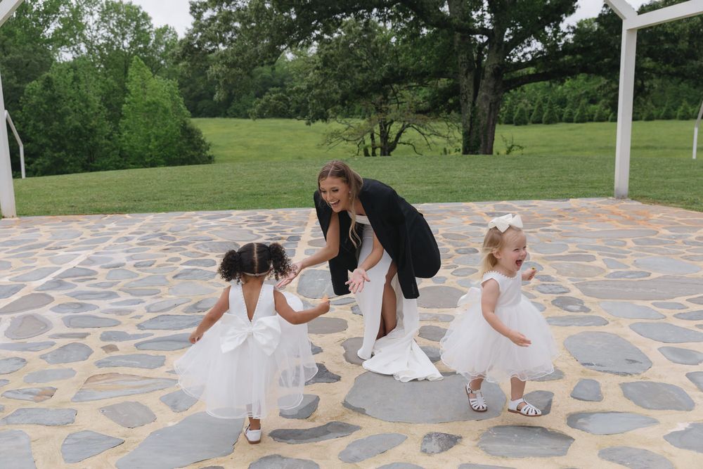 Bride playing with her flower girls on her wedding day at the venue at twin oaks
