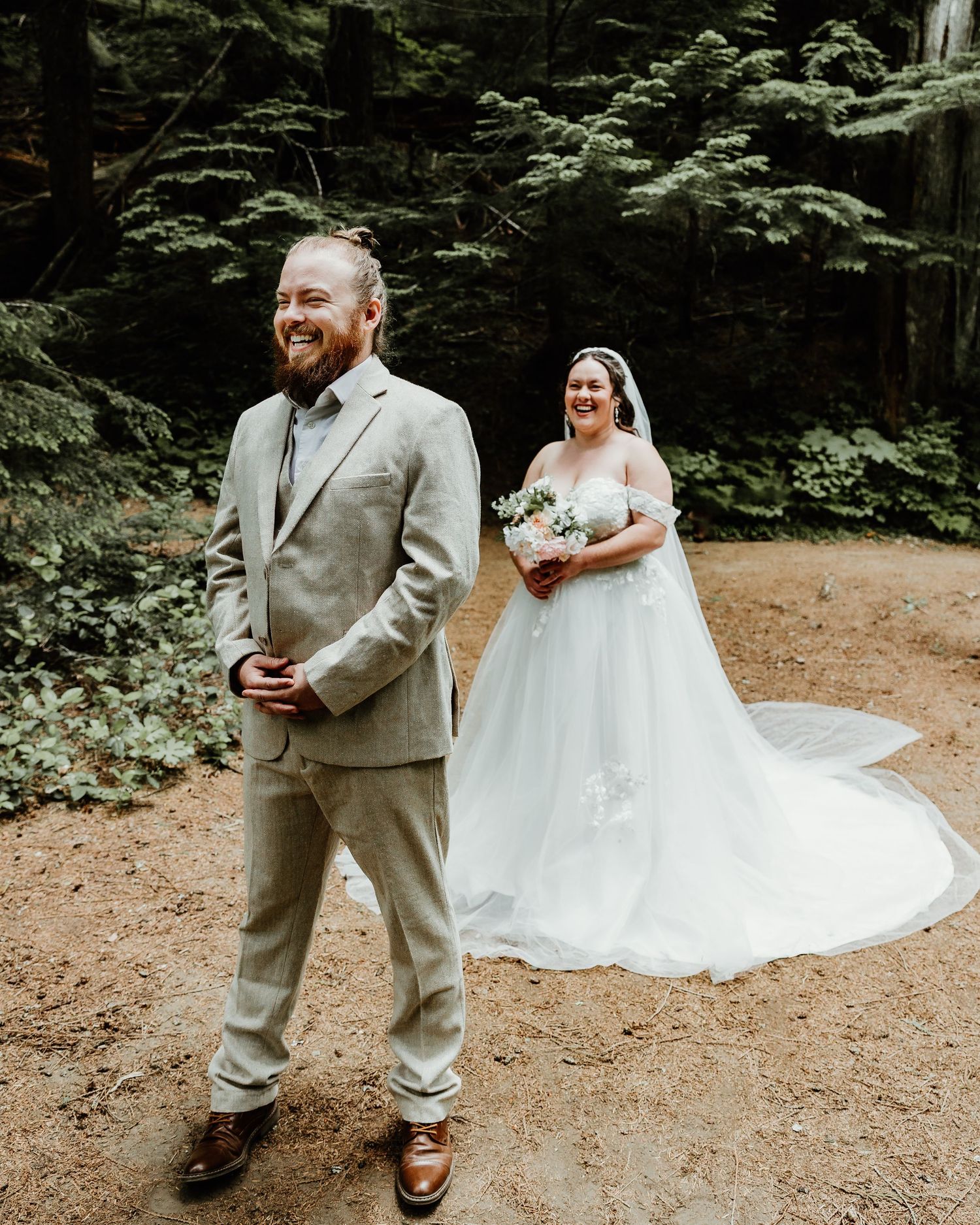 Wedding couple shares joyful candid moments while walking together in a tranquil forest setting. emotional first look photos. Washington