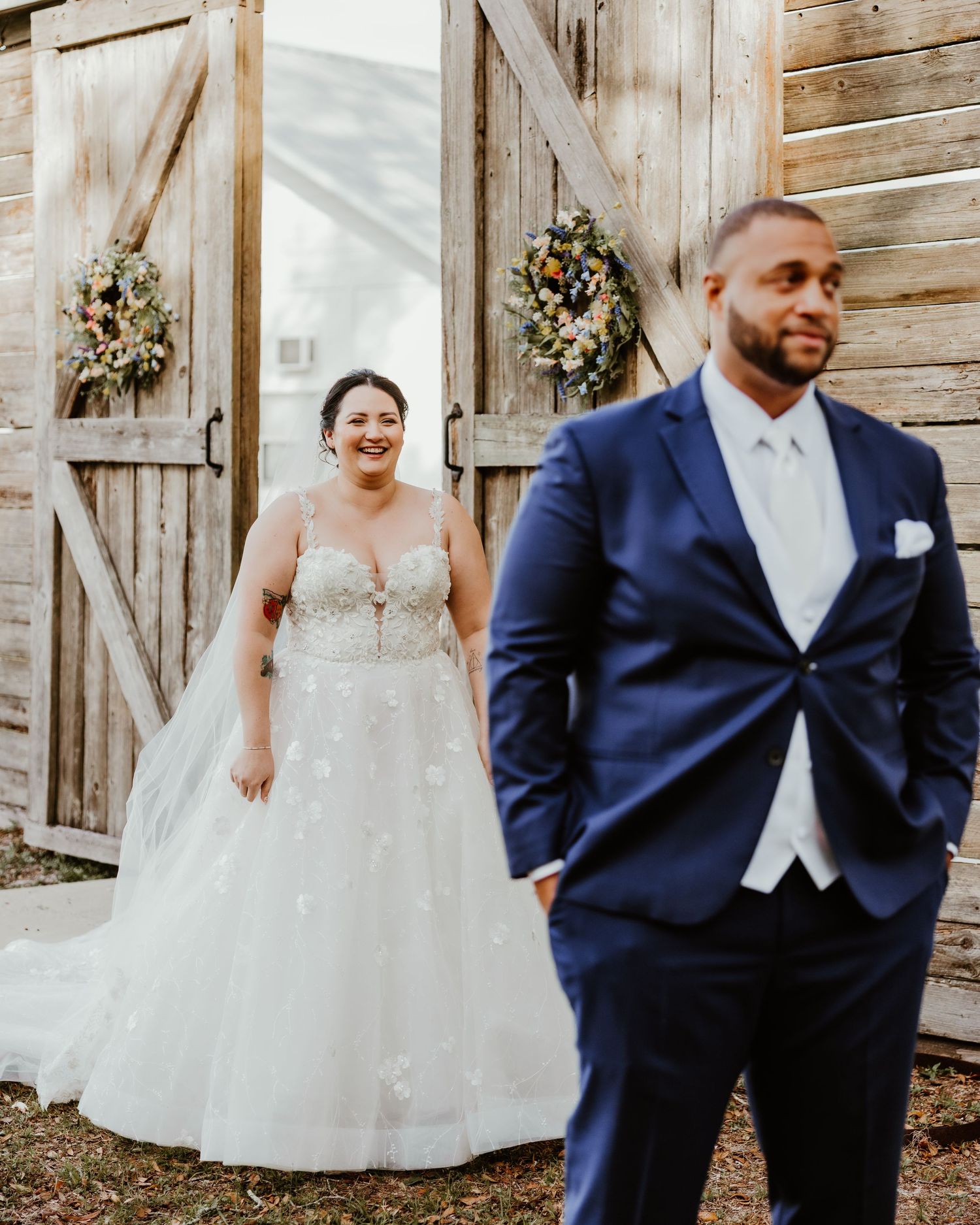 Playful wedding portraits against wooden barn backdrop showing couple in formal attire.