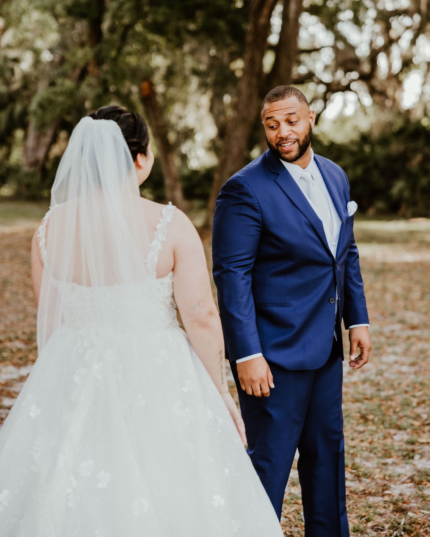Wedding sequence showing couple in navy suit and white gown against natural outdoor setting.