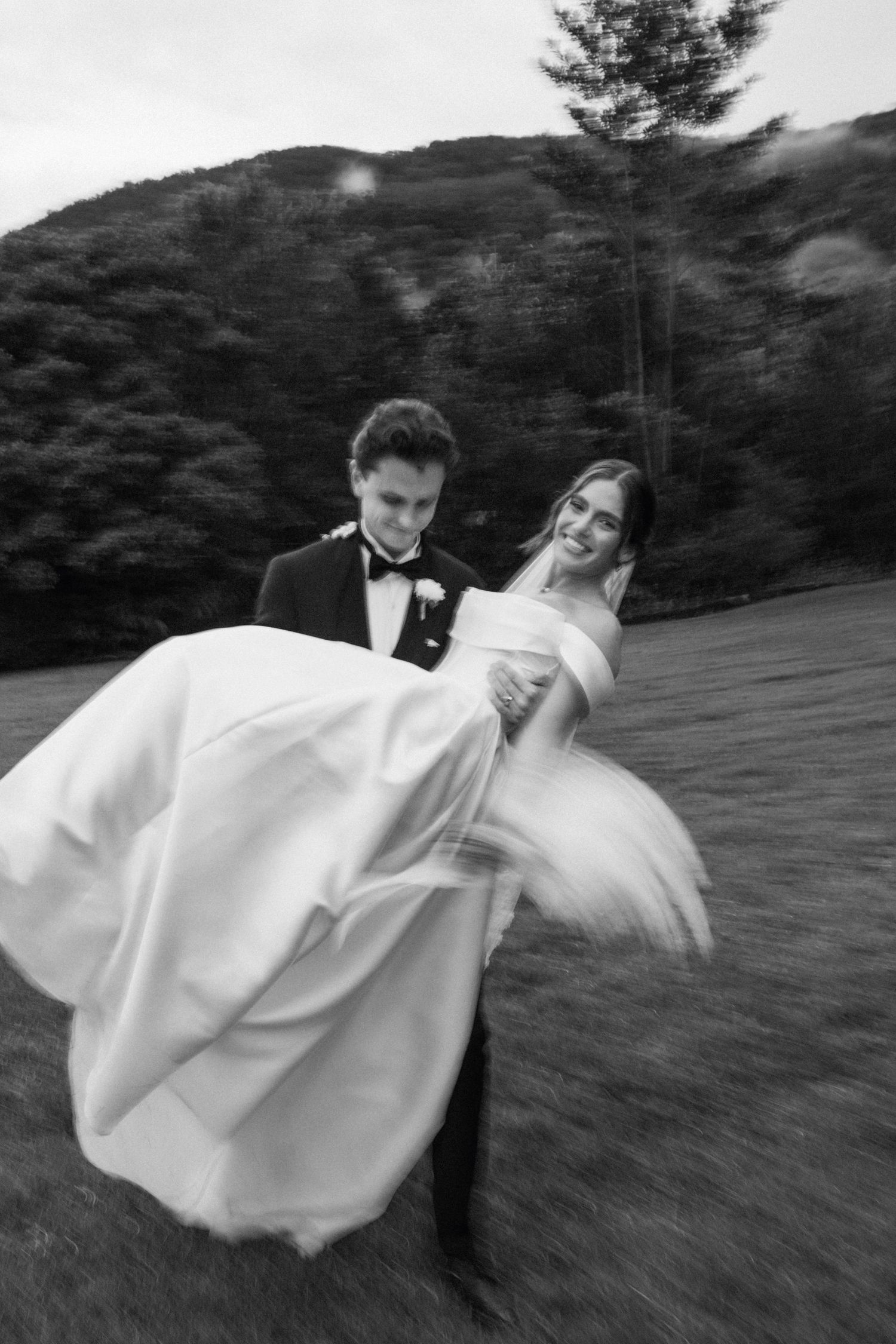 Black and white photo sequence of a groom carrying his bride in an elegant twirling motion outdoors on a hillside.