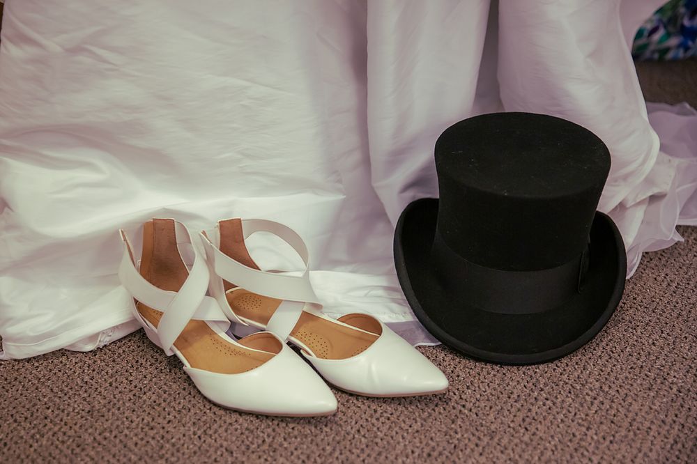 A series of wedding detail photos showing white dress, formal shoes, and black top hat arranged on carpet.