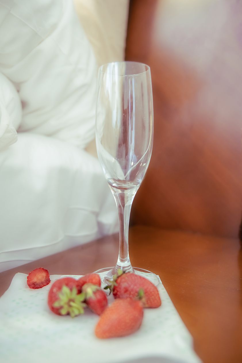 A sequence of champagne flutes with fresh strawberries on a white cloth surface in varying focus and composition.