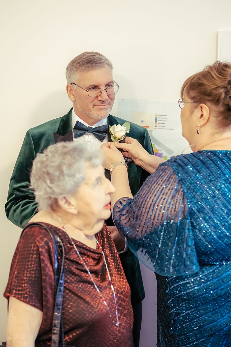 A series of four connected images showing a healthcare worker adjusting the collar of an elderly patient in burgundy.