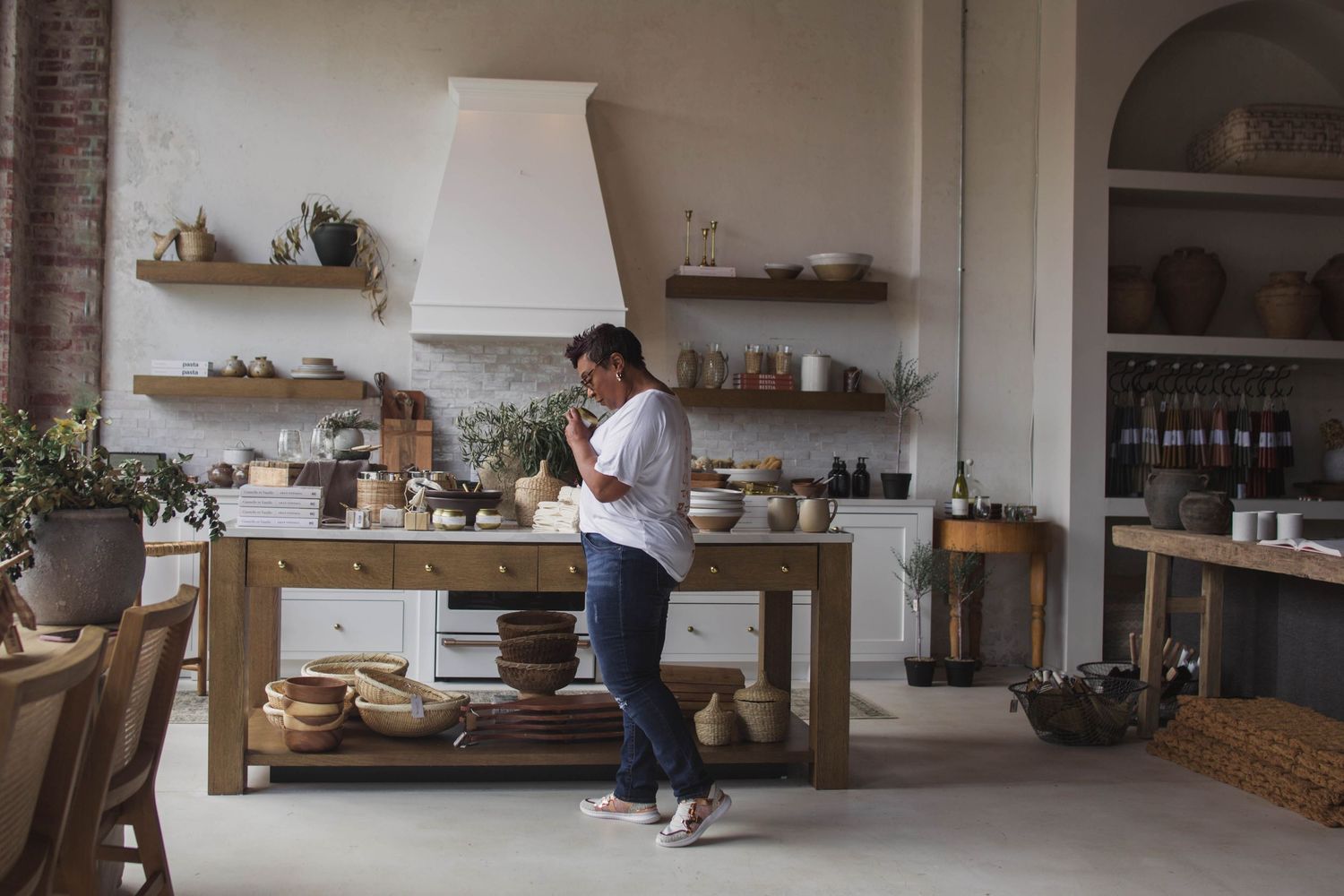 Contemporary retail space interior with exposed brick walls and wooden floating shelves.