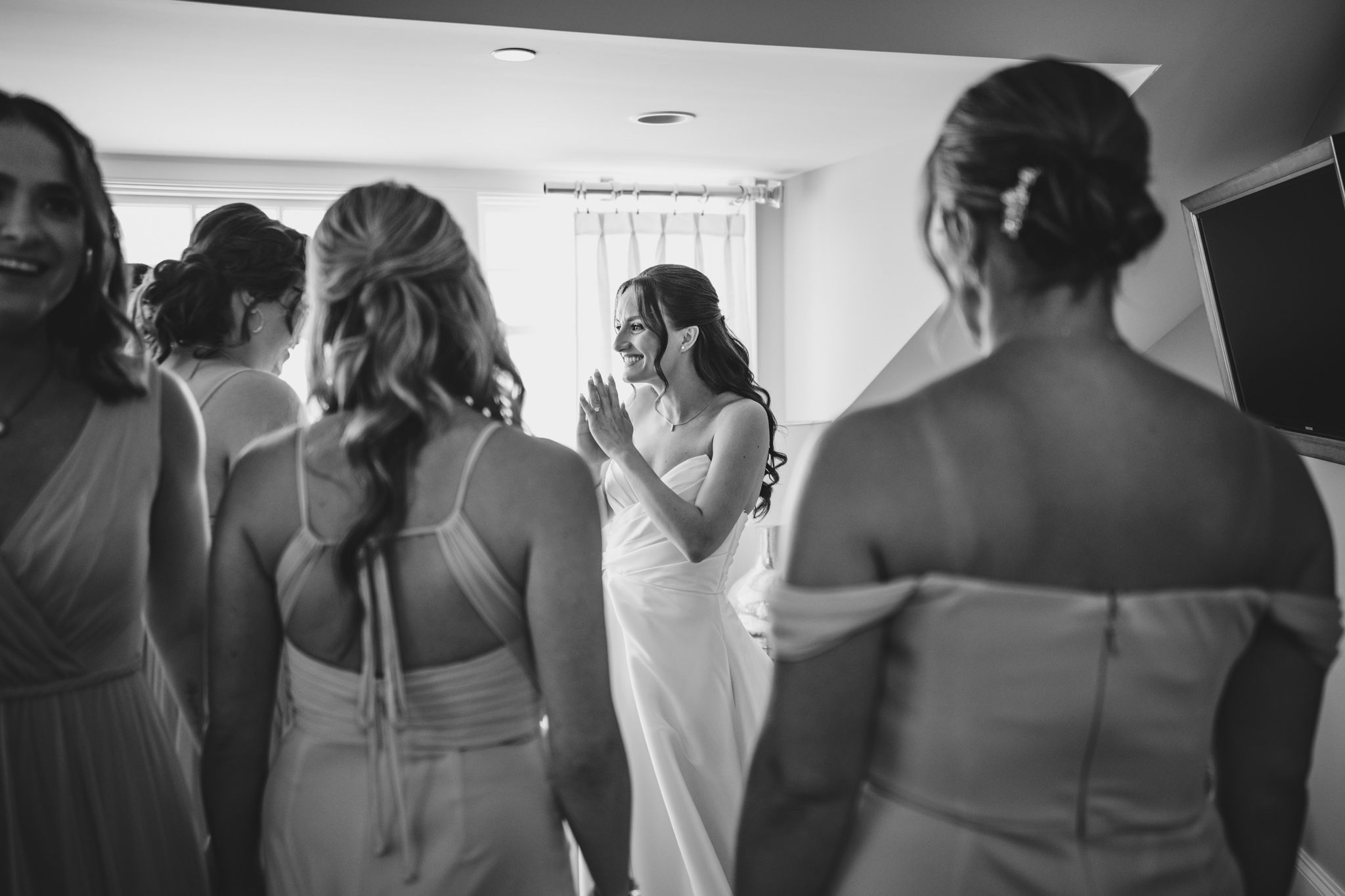 Black and white image of bridesmaids helping with wedding preparations.