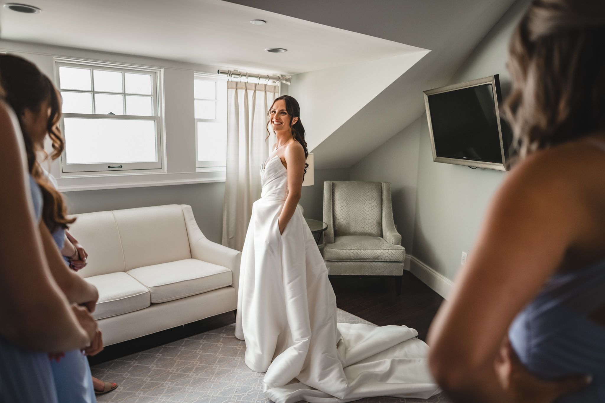Wedding dress preparation scene in bright natural light with white curtains and elegant decor.