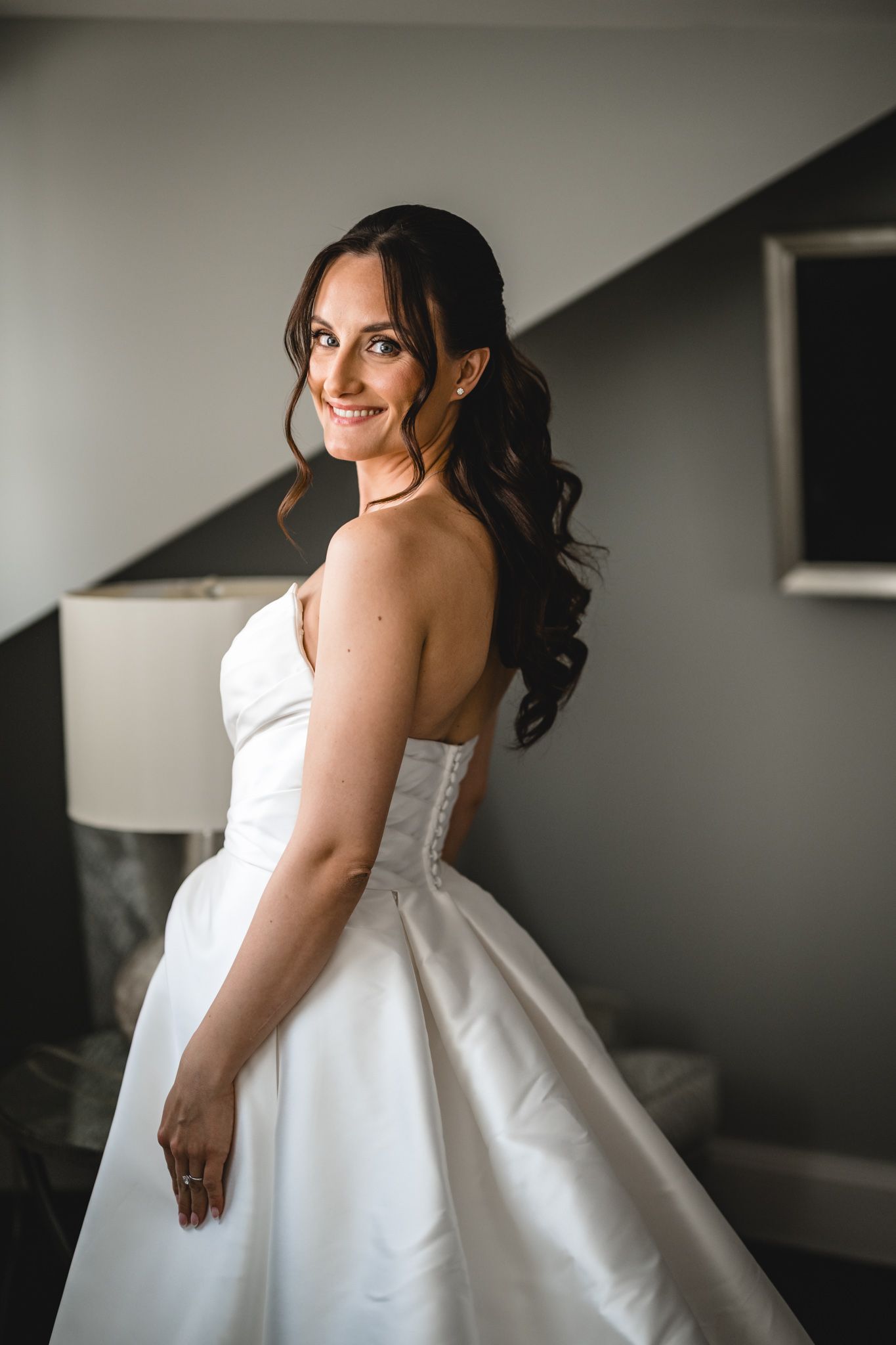 Beautiful white ballgown wedding dress details shown in an intimate getting ready scene.