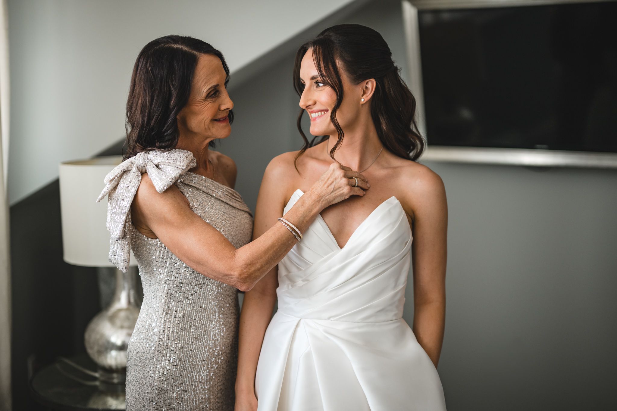 Candid moments between bride and bridesmaid in formal wedding attire.