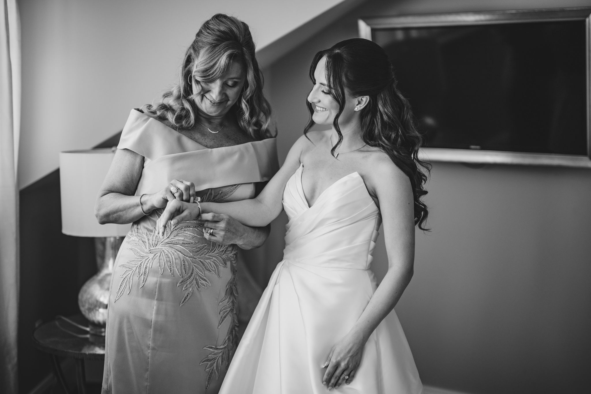 Black and white photo of emotional wedding preparation moments.