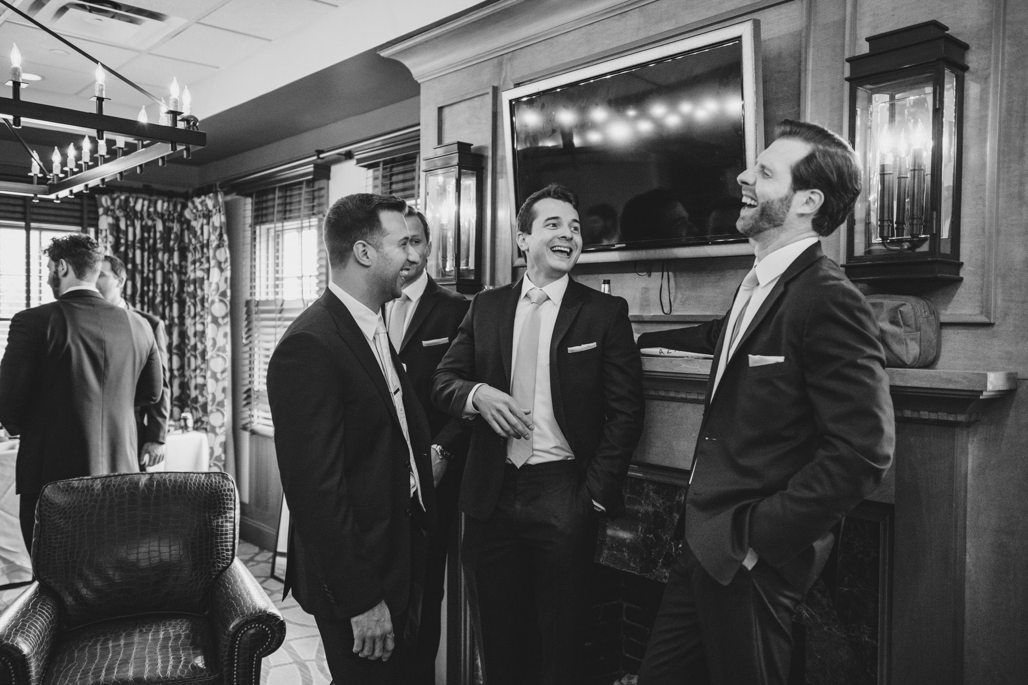 Black and white candid shots of groomsmen laughing and socializing before the ceremony.