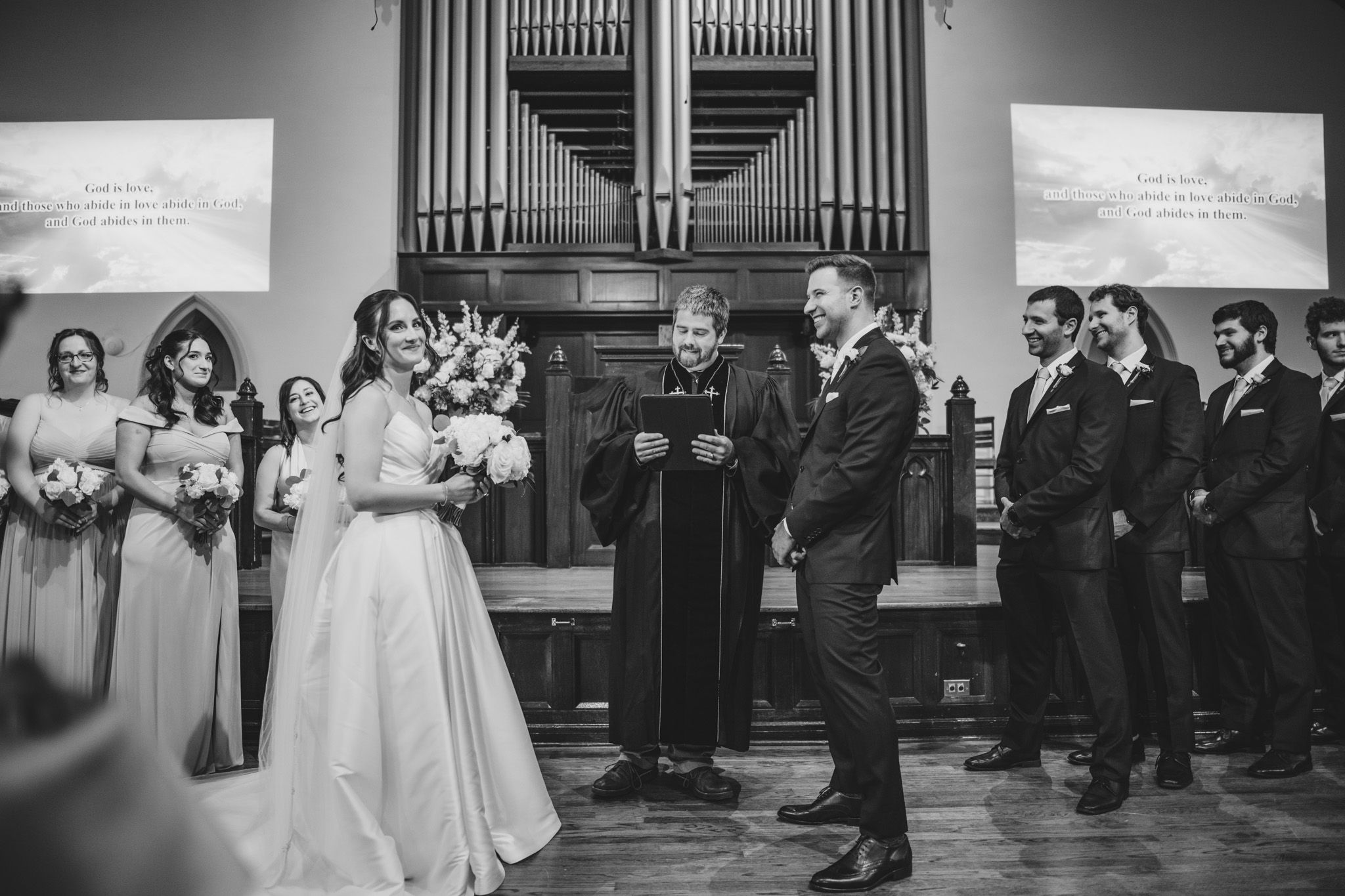 Black and white panoramic view of a wedding ceremony in a traditional church setting.