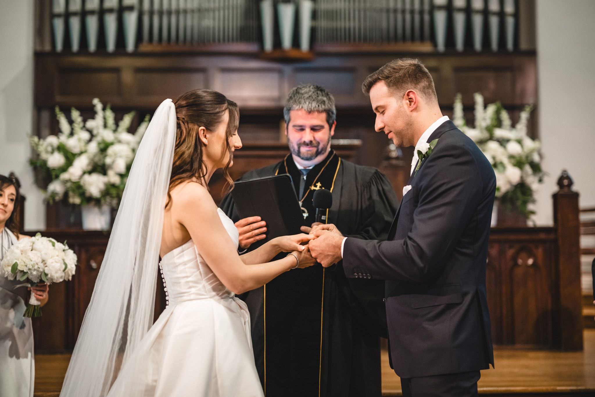 Wedding ceremony in a church with organ pipes and wooden decor in the background.