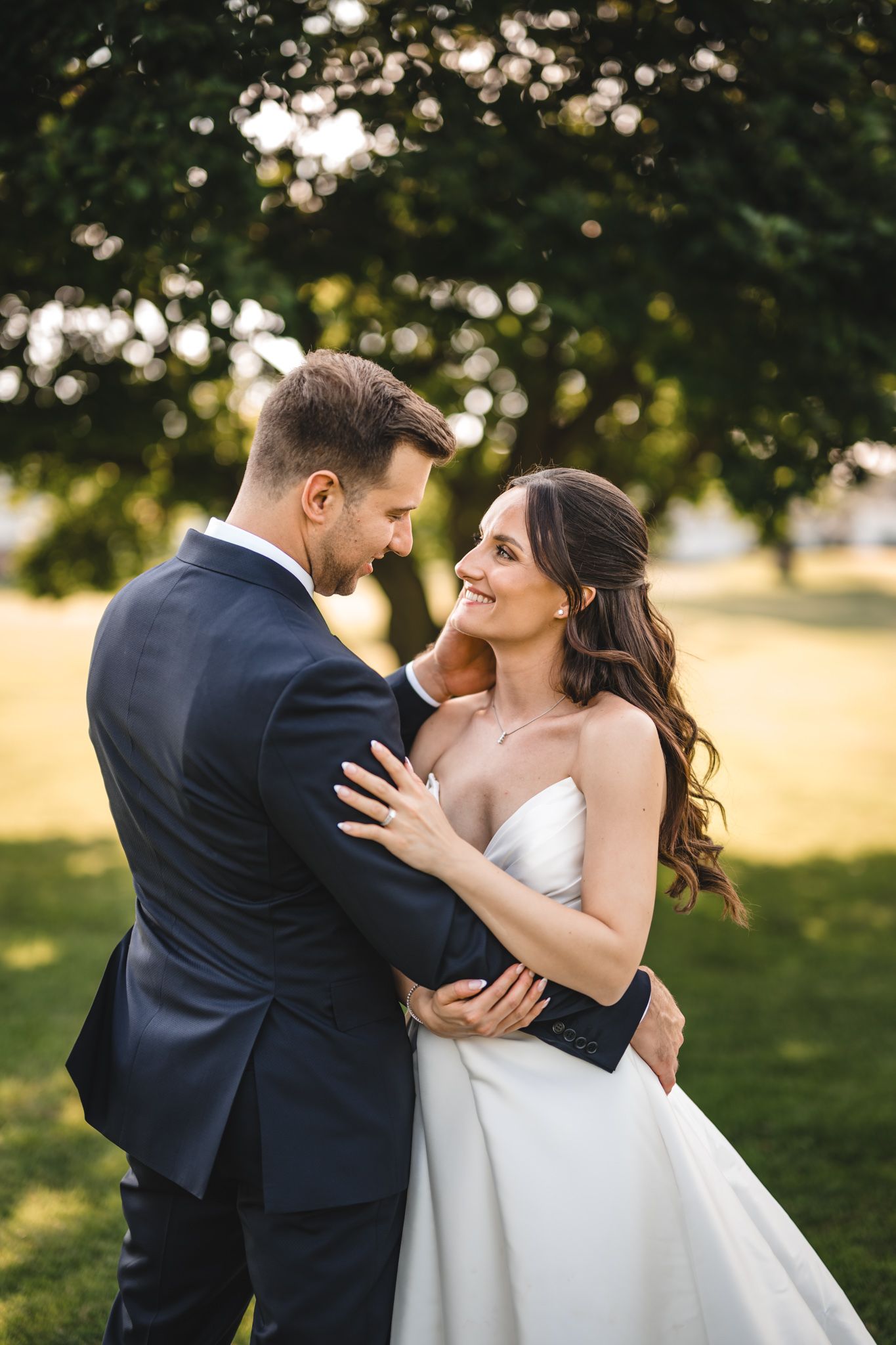Newlyweds share an intimate moment while dancing together outdoors during golden hour.