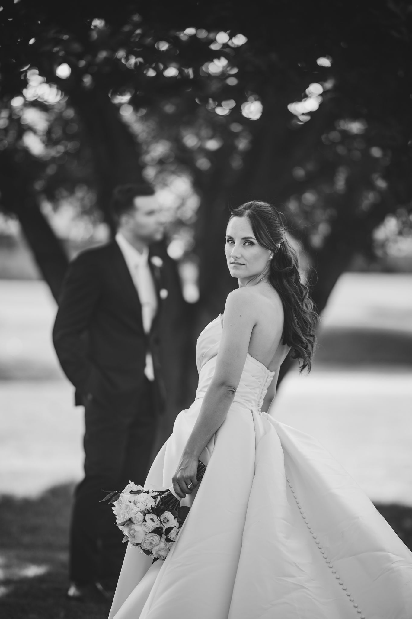Black and white portrait of a bride in an elegant ballgown wedding dress.