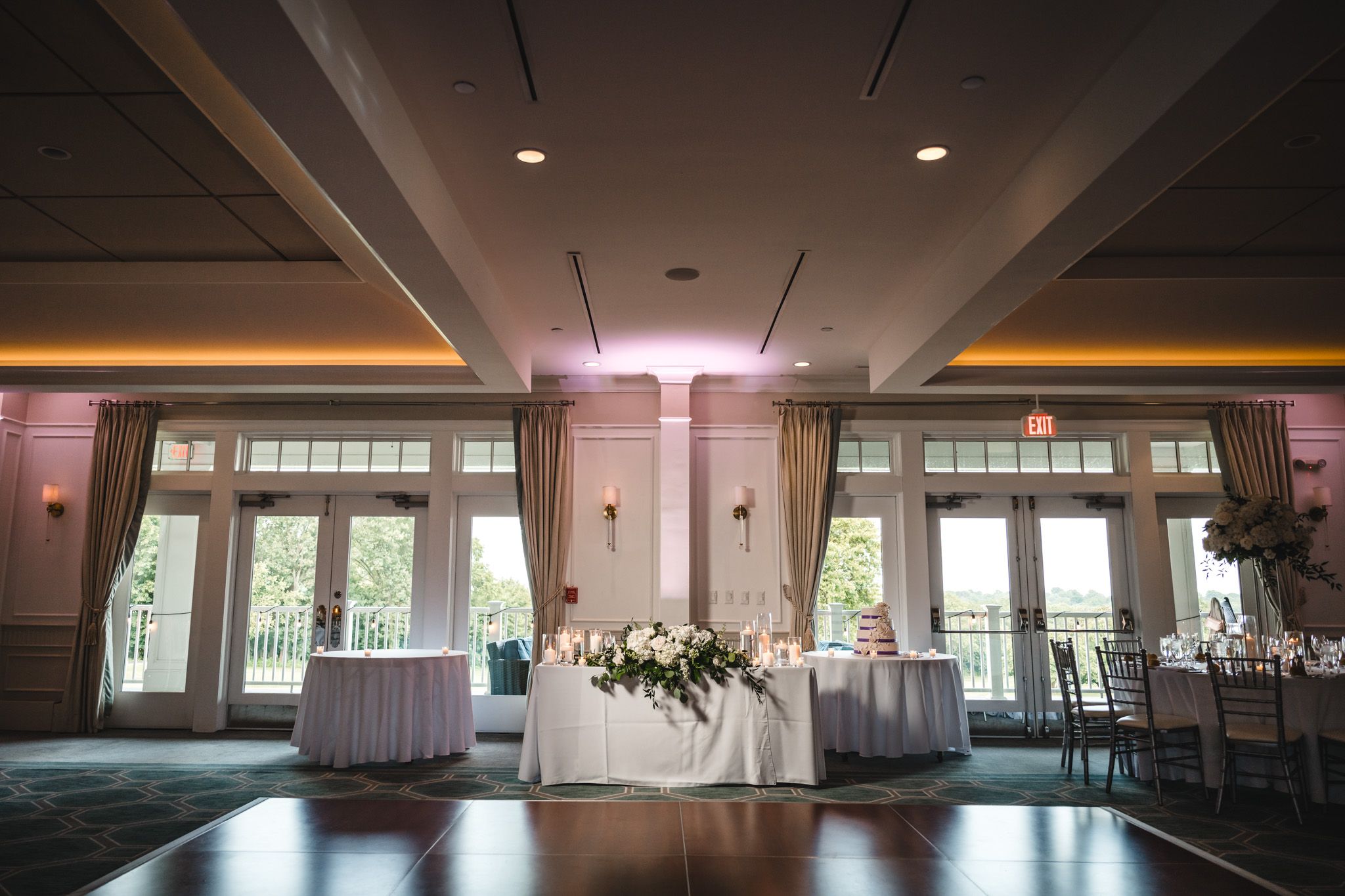 An elegant wedding reception venue with large windows and natural lighting.