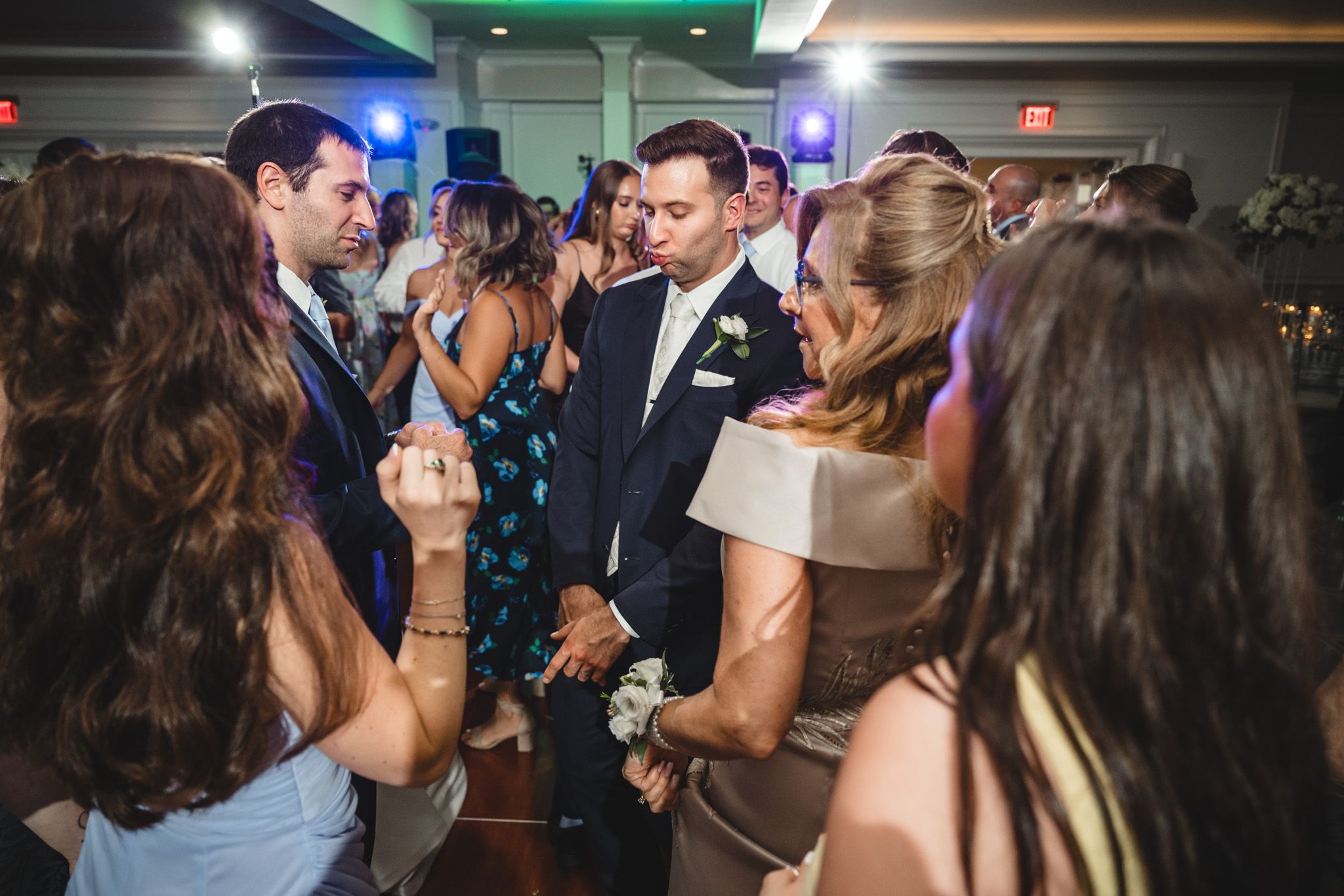 Energetic dance party scene with guests enjoying celebration under ambient lighting.