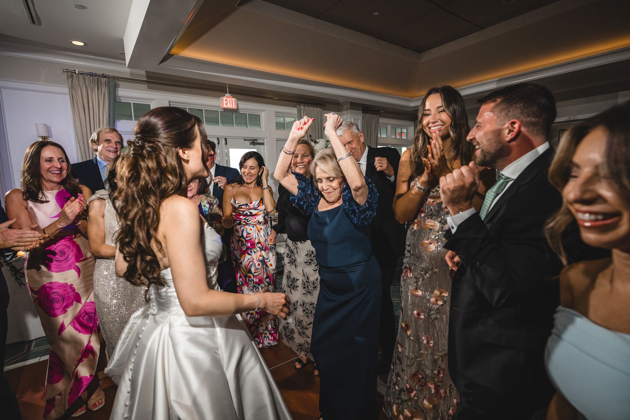Wedding reception dance party with guests celebrating on crowded dance floor.