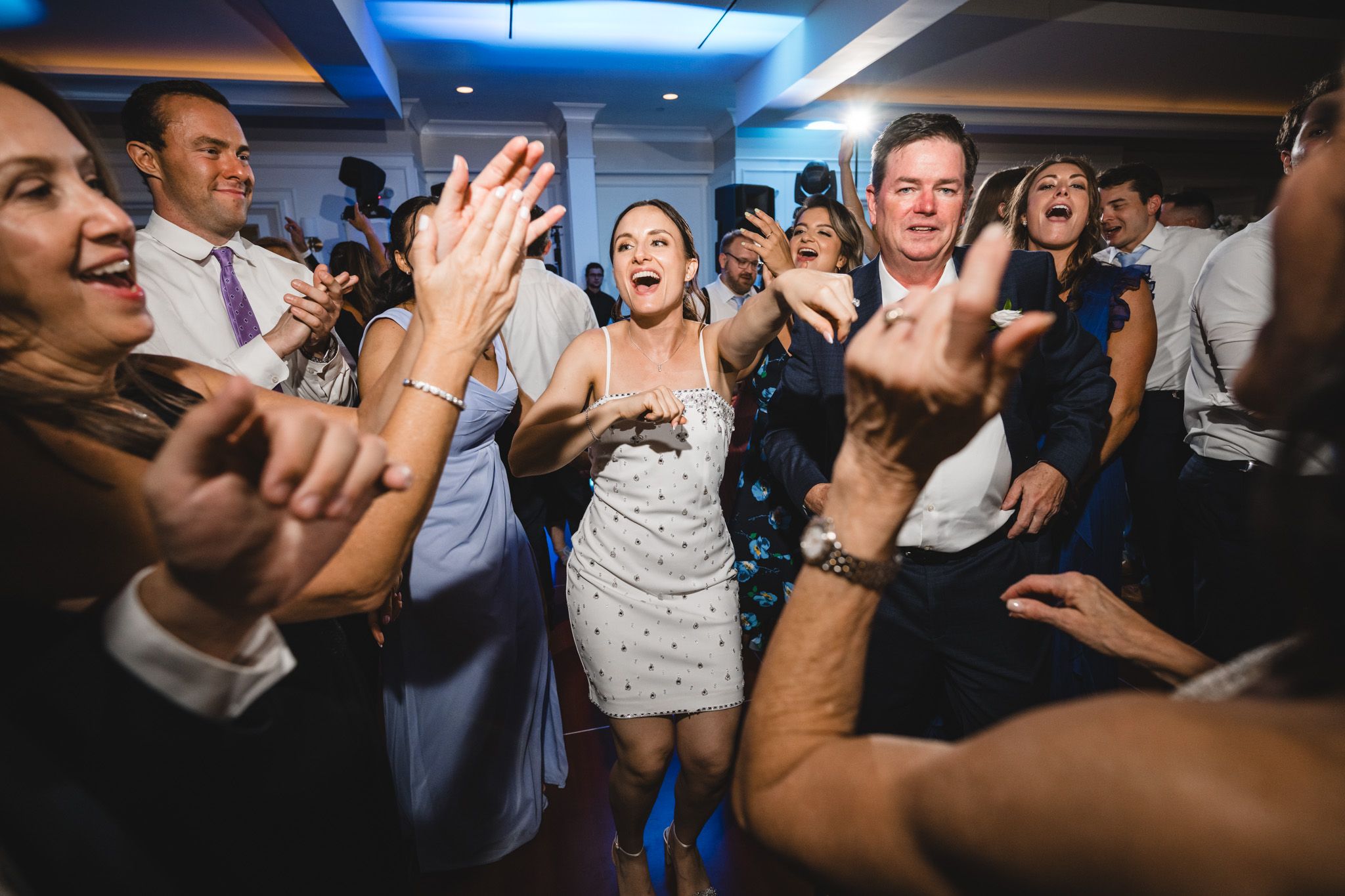 Dynamic party scene with blue lighting and guests dancing enthusiastically.