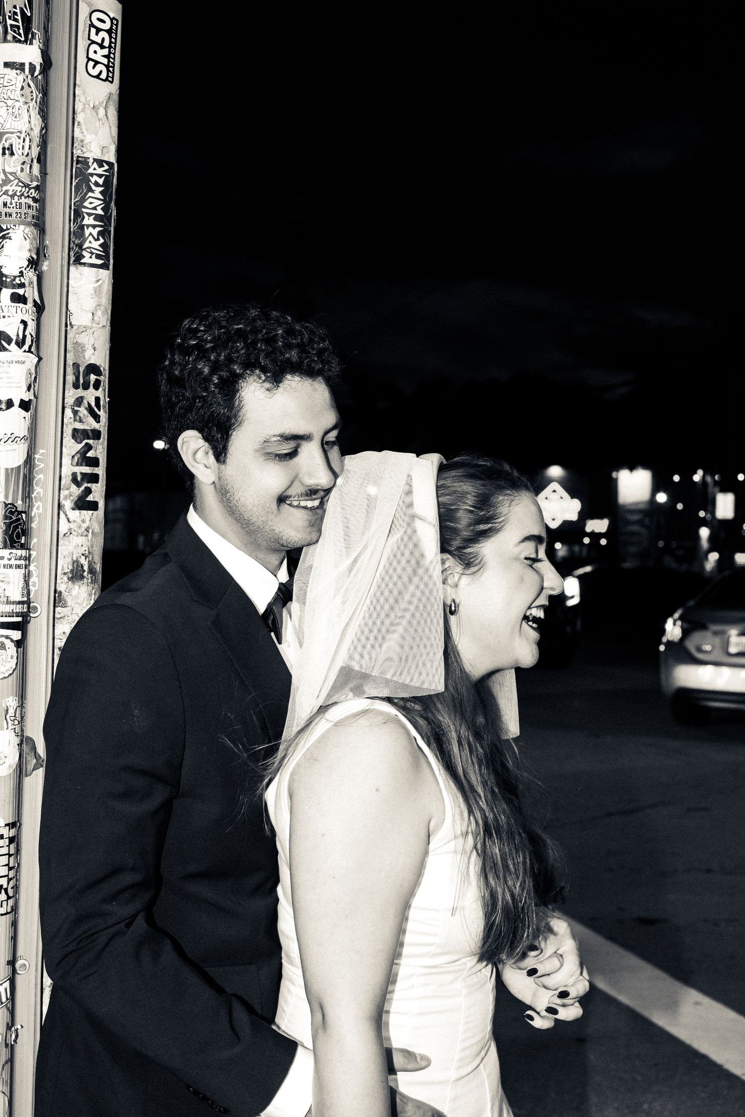 A candid black and white photo capturing a couple at a nighttime event.