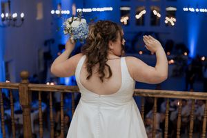 Bride preparing for the bouquet toss at the Grand Ivory on the balcony overlooking guests in a fall October wedding in Moncton New Brunswick