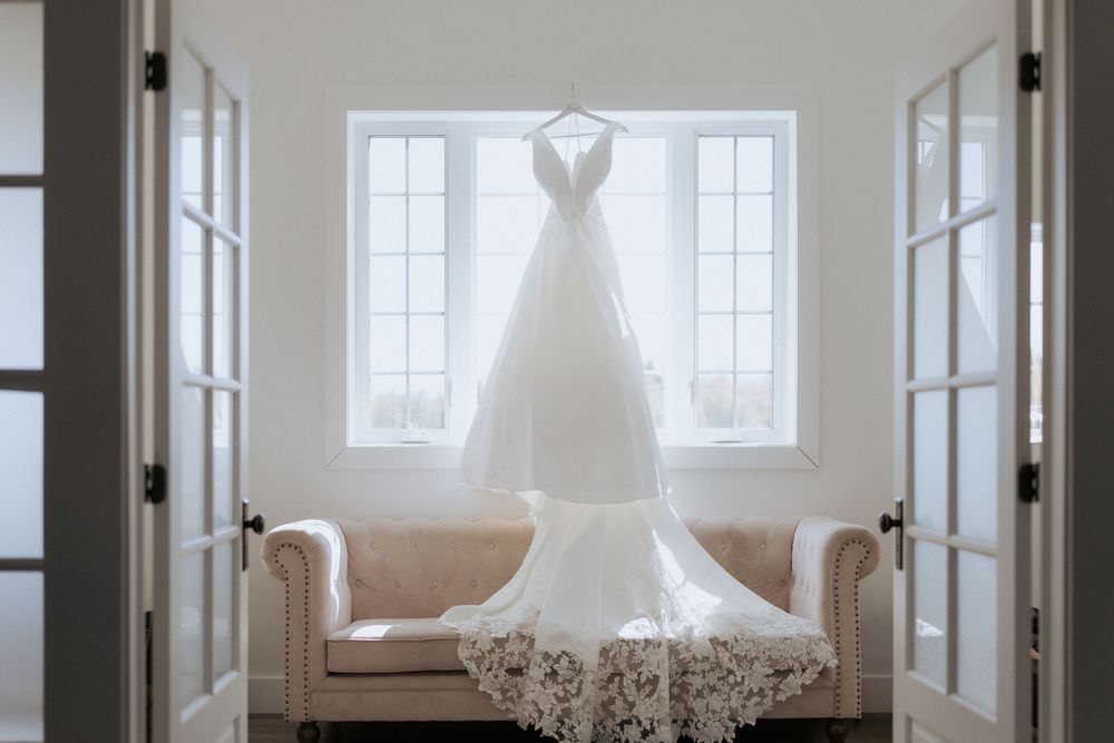 Elegant wedding dress hangs in the window at the Grand Ivory, New Brunswick wedding photographer, experienced photographer, timeless wedding