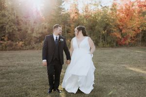 Bride and groom walk hand in hand with colourful trees behind them as the sun sets at Grand Ivory, Moncton wedding photography, NB