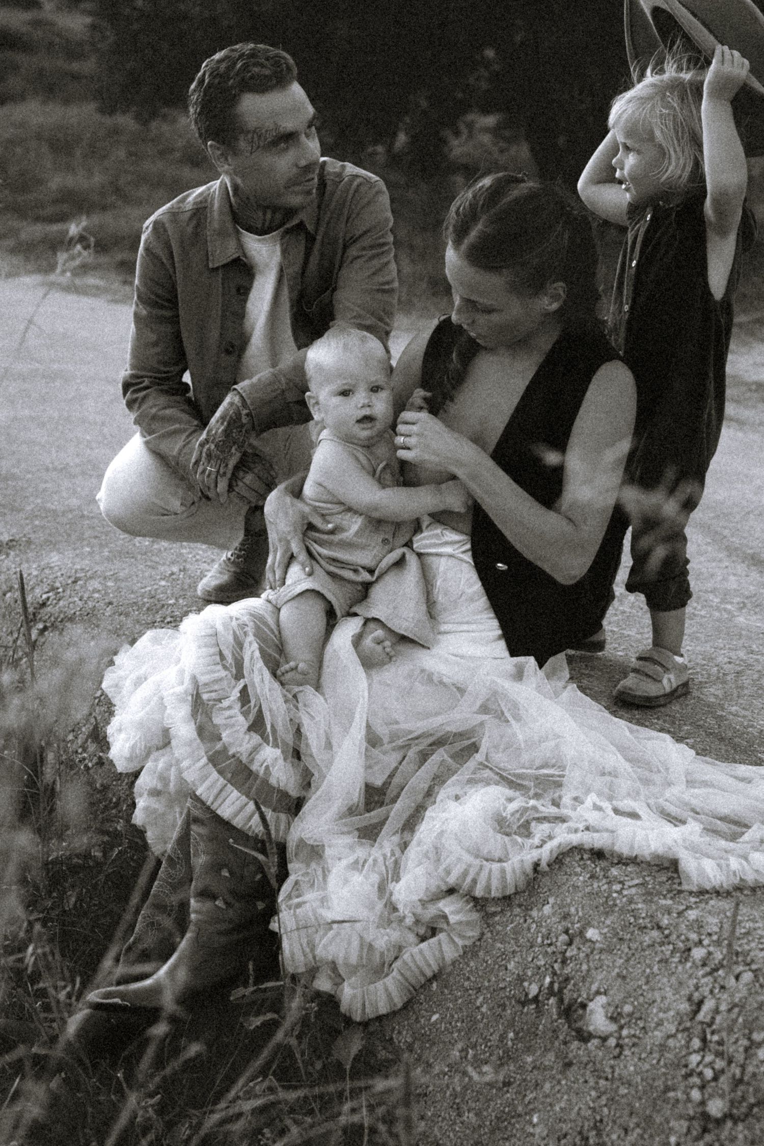 A series of black and white photos showing tender moments between parents and a young child sitting outdoors. Javea photographer