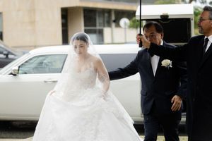 Wedding party walking outside a building with the bride's veil flowing in the breeze.