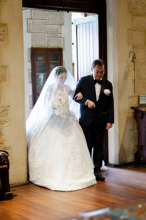 Sequence shows bride in flowing white gown walking through historic stone hallway.