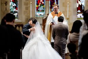 Wedding ceremony in a traditional church with elegant white decor and stained glass windows.