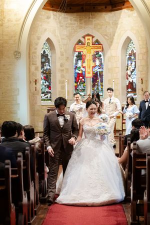 Wedding ceremony in a church with stained glass windows and traditional decorations.
