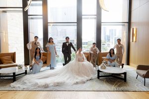 Wedding party poses in modern high-rise venue with city views and elegant decor.
