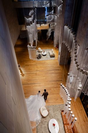 A wedding venue with dramatic hanging crystal chandeliers and hardwood floors viewed from above.