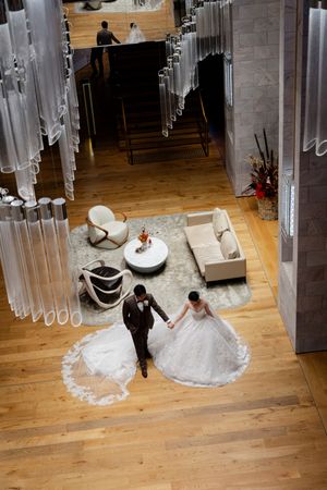 Four sequential photos show a wedding couple gracefully twirling on a hardwood floor in a bridal boutique.
