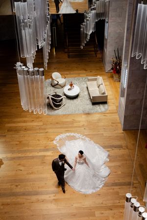 Wedding couple twirls on wooden floor under hanging crystal decor in sequential action shots.