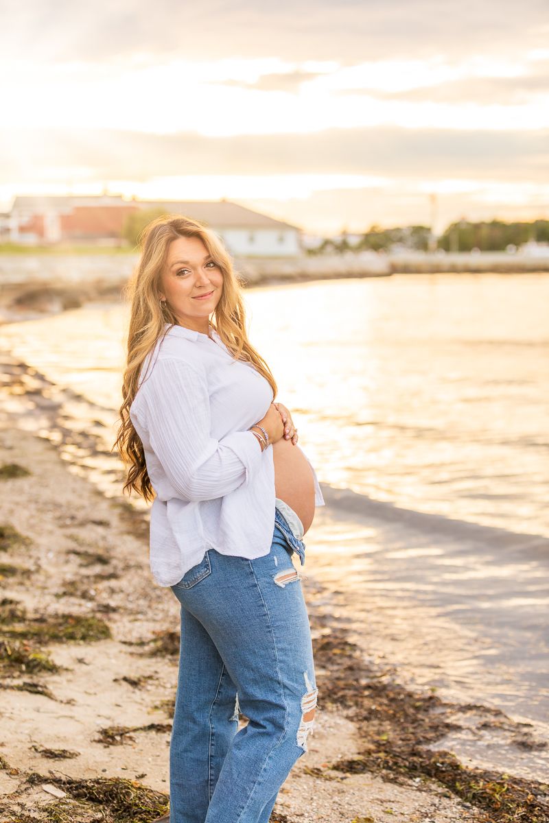 A sunset photo at a beach with warm golden lighting illuminating the shoreline and coastal scenery.