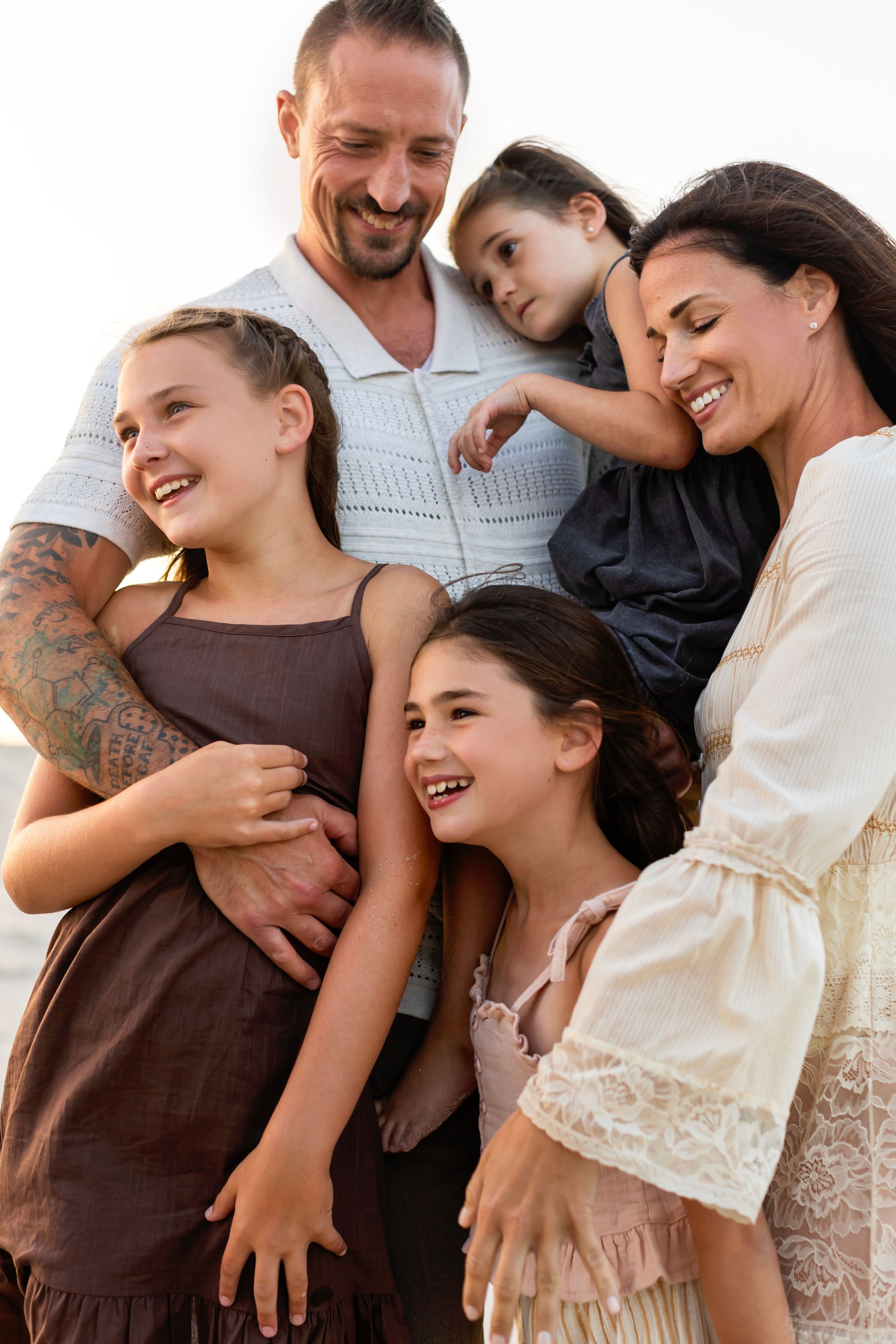 A candid family photo series showing playful and affectionate moments in neutral colored clothing.